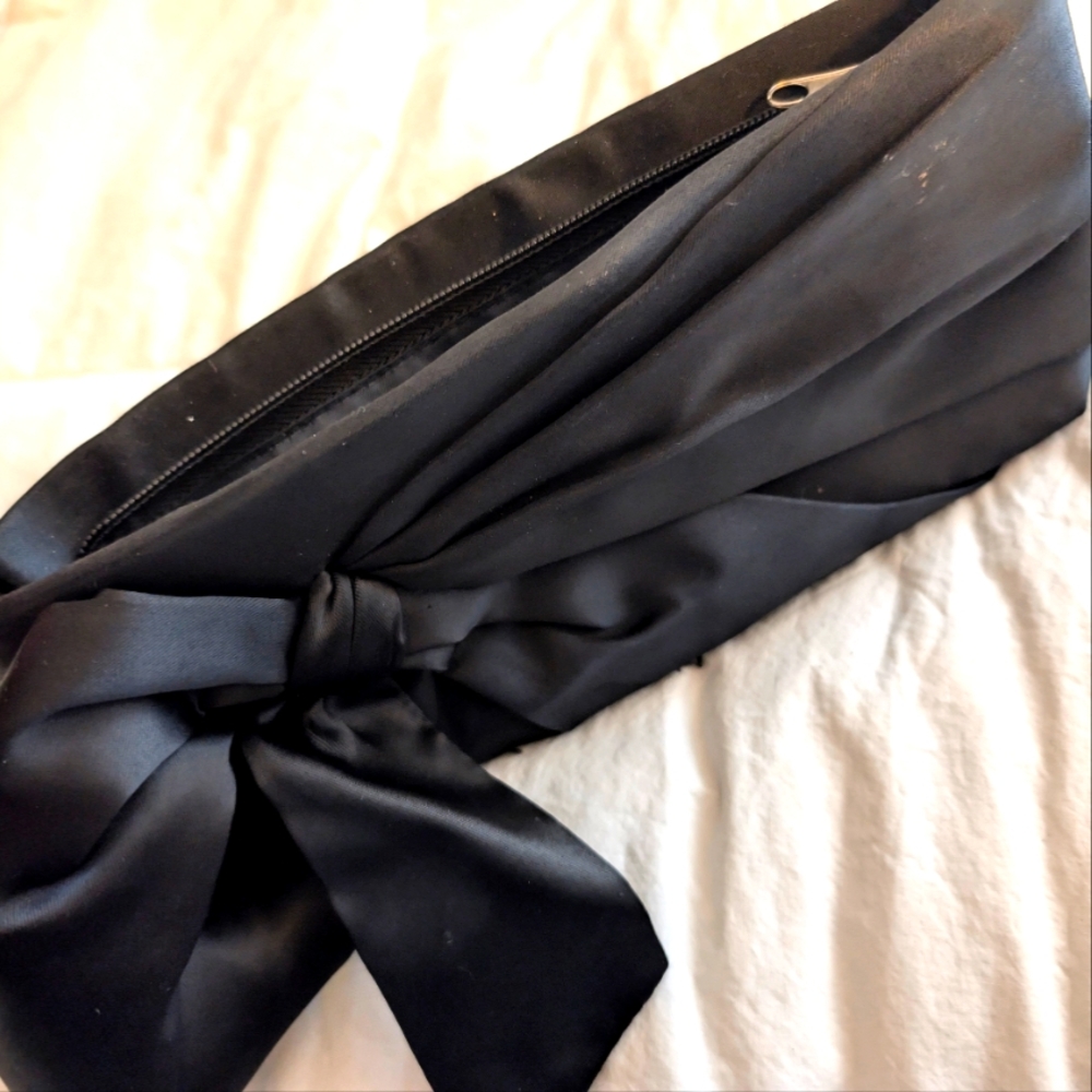 Black hand held purse with side bow